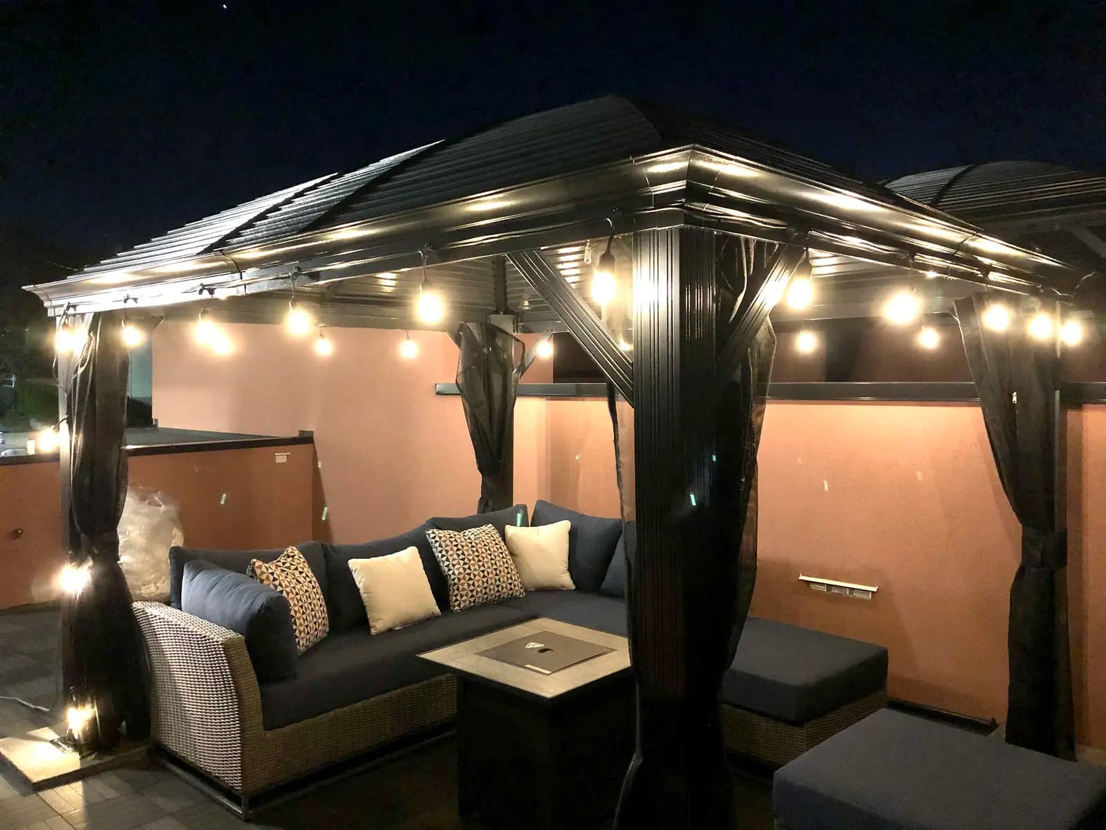 Rooftop gazebo at night with string lights