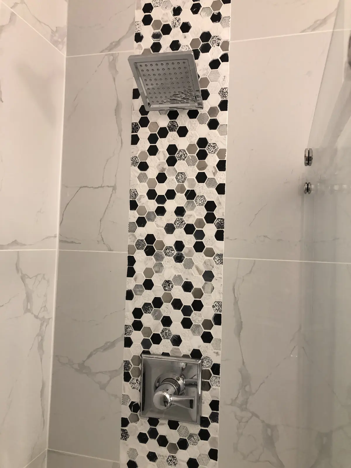Aisha's Jewel guest bathroom with hexagon tile, black and white marble and rain shower head