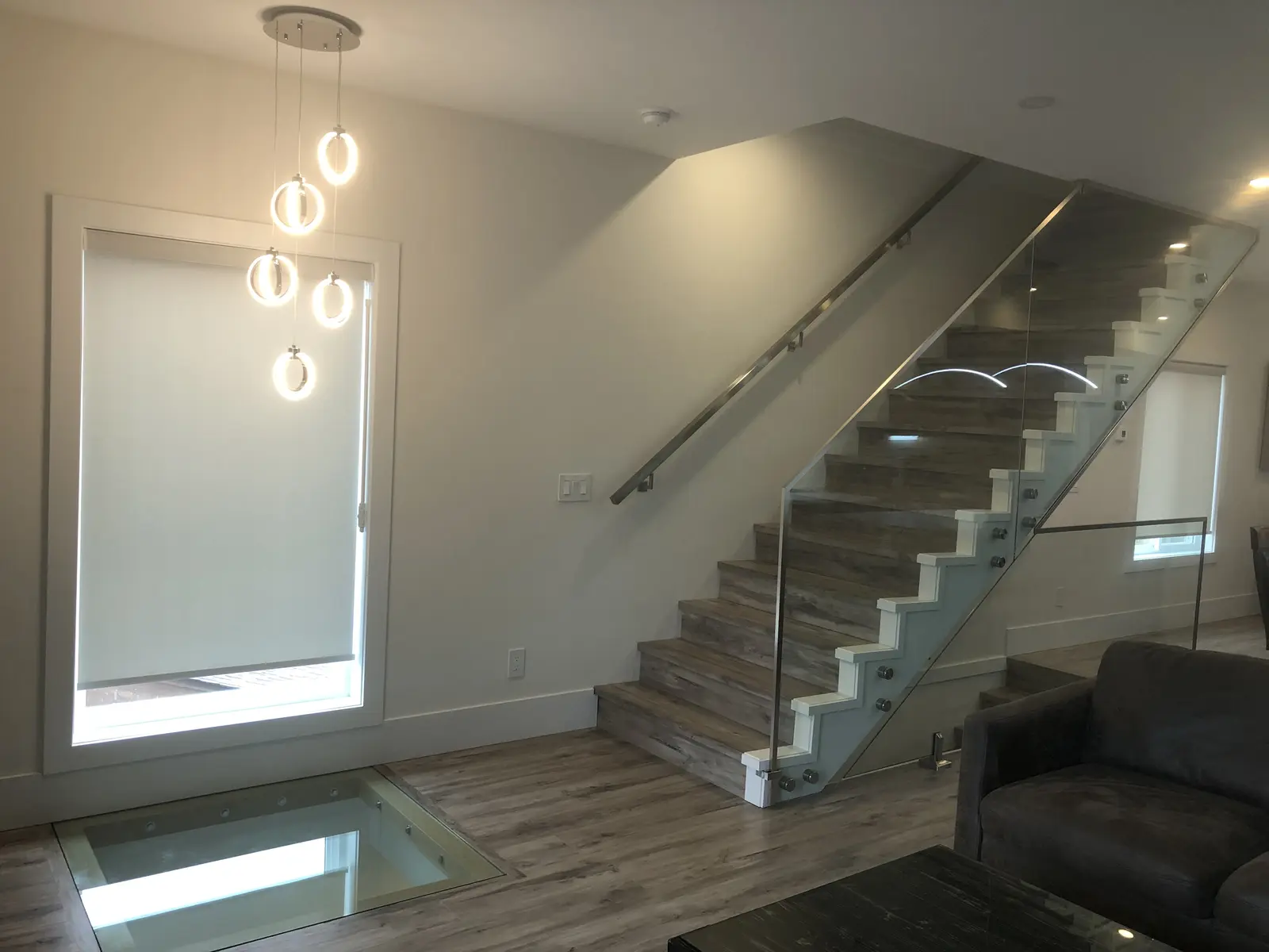 Aisha's Jewel contemporary staircase with glass railing and pendant chandelier lights