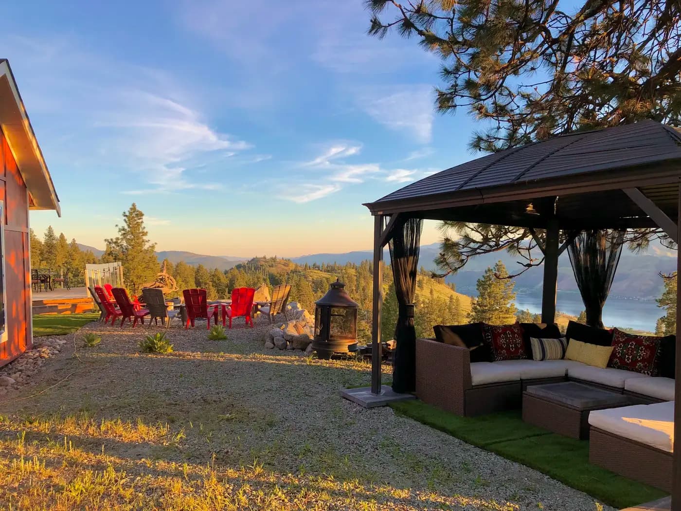 Covered gazebo lounge with sectional seating overlooking Osoyoos Lake at golden hour