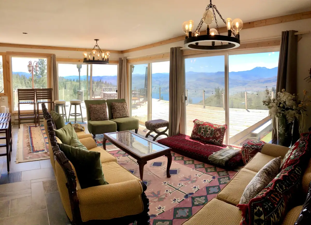 Wide angle view of Vista Peak living room with lake views and sliding glass doors to deck