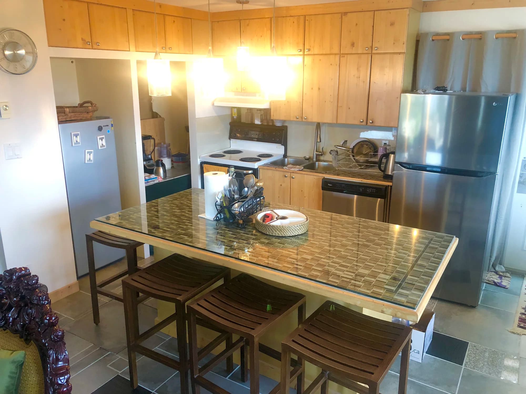 Vista Peak kitchen with glass island, knotty pine cabinets and stainless steel appliances